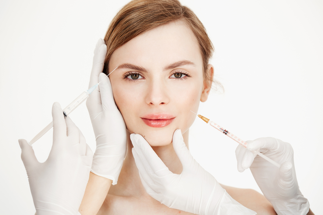 Cosmetologists hands making medical botox injections to beautiful blonde. Skin lifting. Facial treatment. Beauty and spa. Cosmetologists hands making medical botox injections to beautiful blonde. Skin lifting. Facial treatment. Beauty and spa.